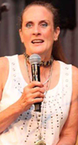A close up photo of Sue Hobbs speaking with a hand-held microphone