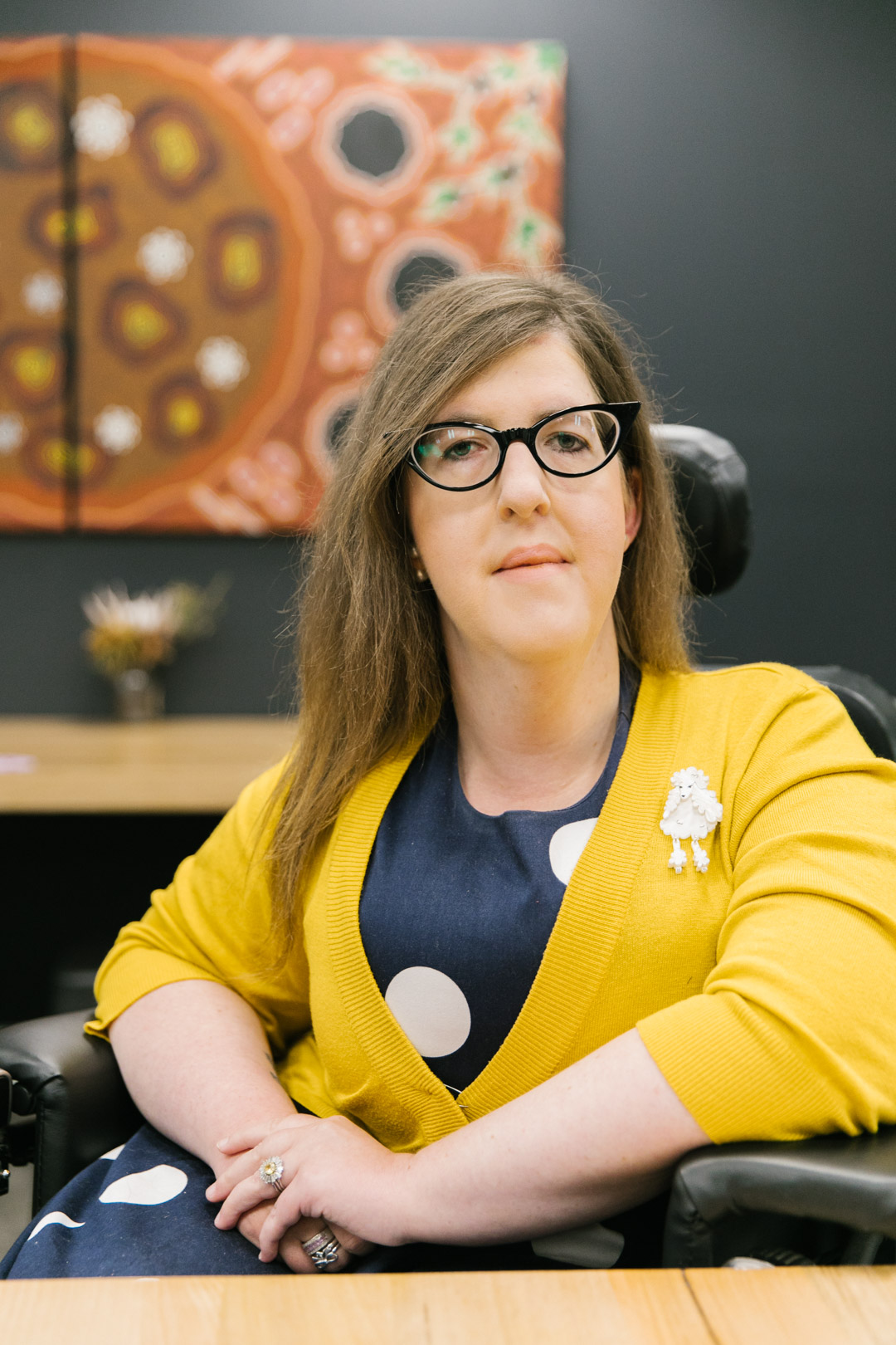 Close up photo of Natalie Wade at a desk with artwork in the background